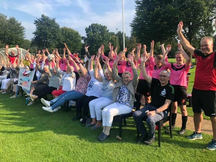 Voetballende meiden en ouderen tijdens het spel Buitenspelval